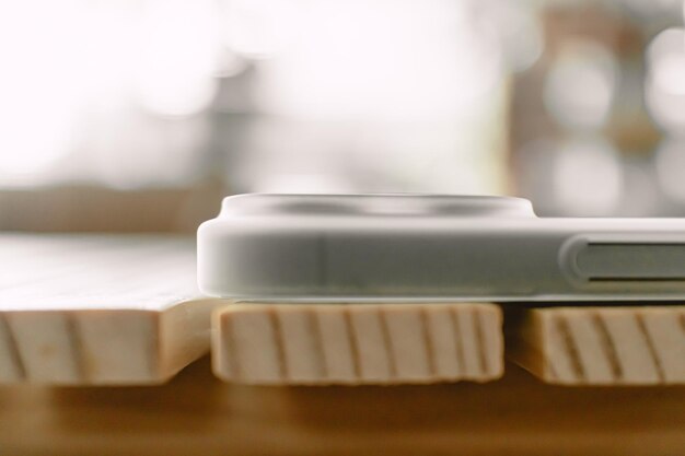 Foto un primer plano de un teléfono móvil con un estuche mate blanco dejado en una mesa de madera