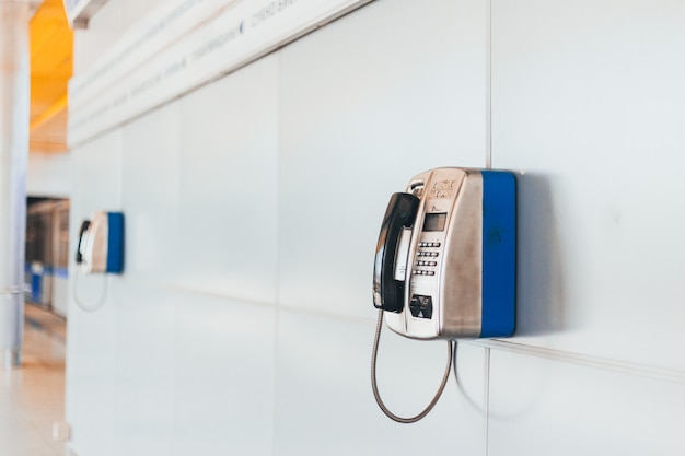 Primer plano de un teléfono público estacionario en la estación de metro por la tarde