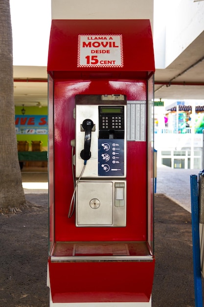 Primer plano de un teléfono público rojo en la ciudad