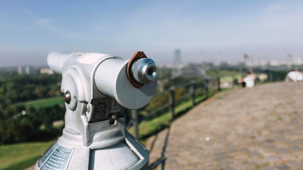 Primer plano de un telescopio accionado por monedas contra el cielo