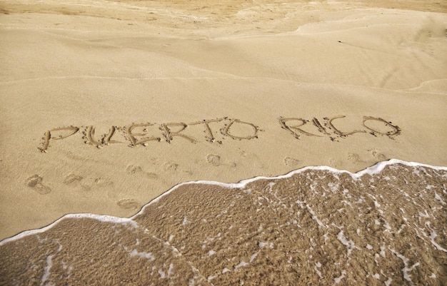 Primer plano de texto en la arena de la playa