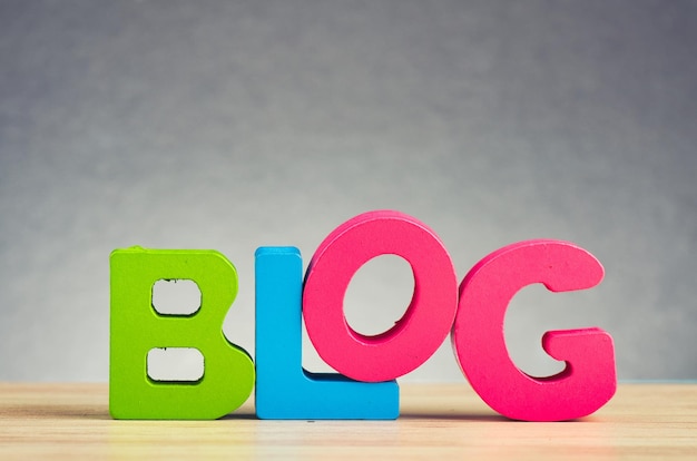 Primer plano del texto del blog en una mesa de madera contra un fondo gris