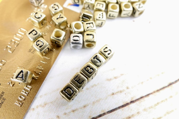 Foto primer plano del texto de la deuda hecho con bloques de juguete dorados en la mesa