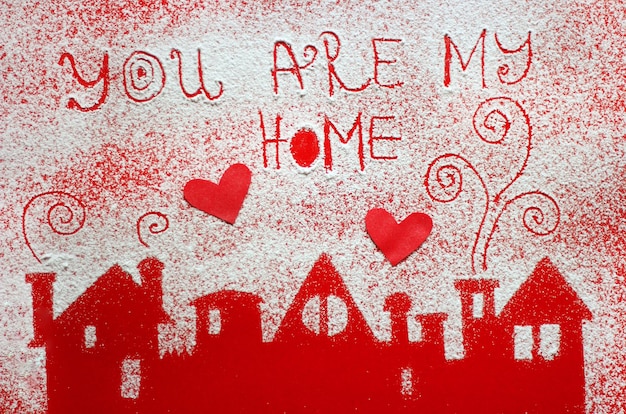 Foto primer plano de texto en fondo rojo con decoración de casas de azúcar en polvo