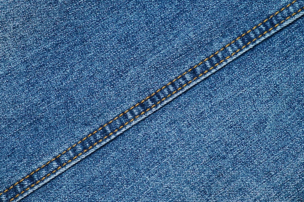 Primer plano de la textura de los pantalones vaqueros azules con costura diagonal Tela de ropa textil de mezclilla