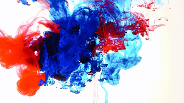 Primer plano de tinta de colores en el agua contra un fondo blanco