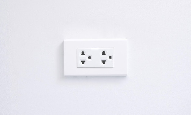 Primer plano de una toma de corriente contra una pared blanca