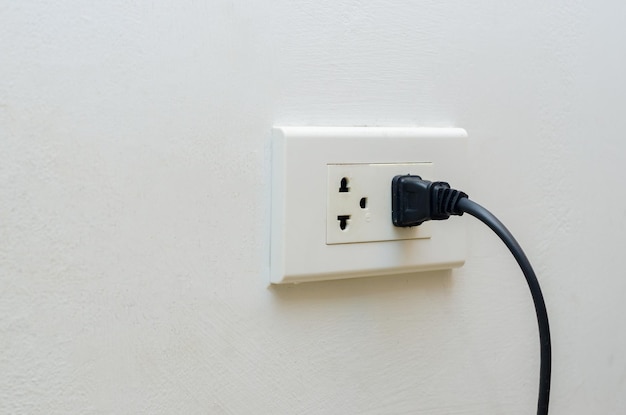 Primer plano de una toma de corriente eléctrica en una pared blanca