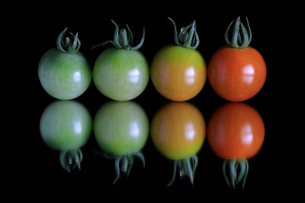 Foto primer plano de tomates sobre un fondo negro