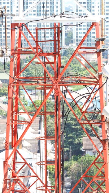 Primer plano de la torre de telecomunicaciones con color blanco y rojo y cielo azul.