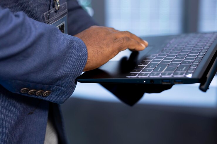 Foto primer plano de un trabajador en un centro de datos usando una computadora portátil