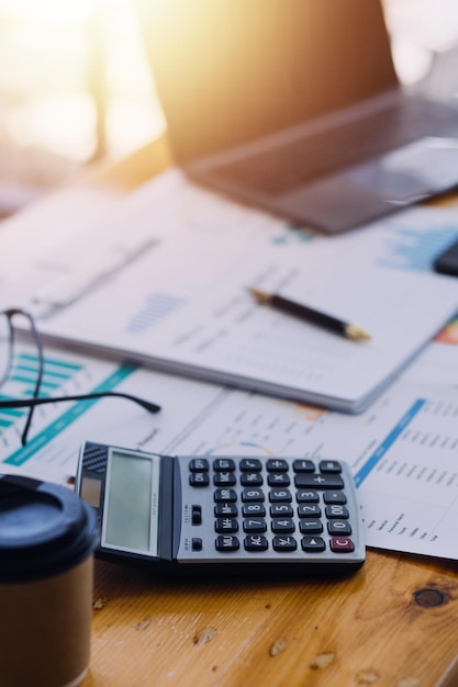 Primer plano del trabajo contable y el análisis de la contabilidad del proyecto de informes financieros con gráfico y calculadora en el concepto moderno de finanzas y negocios de la oficina