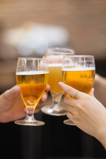 Primer plano de tres vasos de cerveza que se clinked