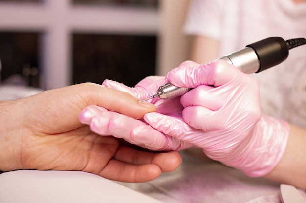 Primer plano de las uñas de una persona que presenta el manicuro en el salón