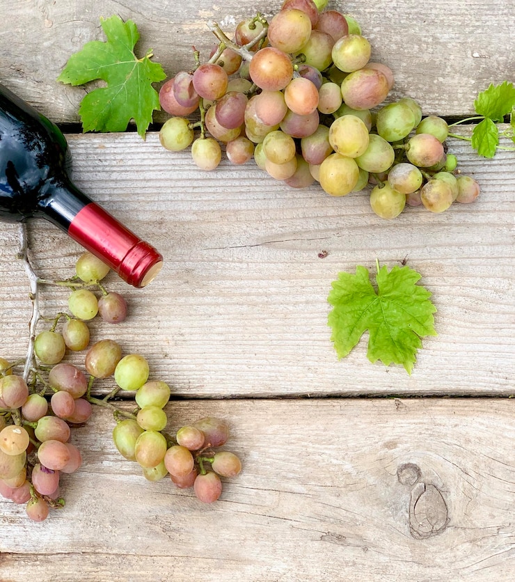 Foto primer plano de uvas y vino sobre un fondo de madera
