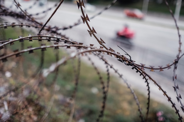 Un primer plano de una valla de alambre de púas en una ciudad