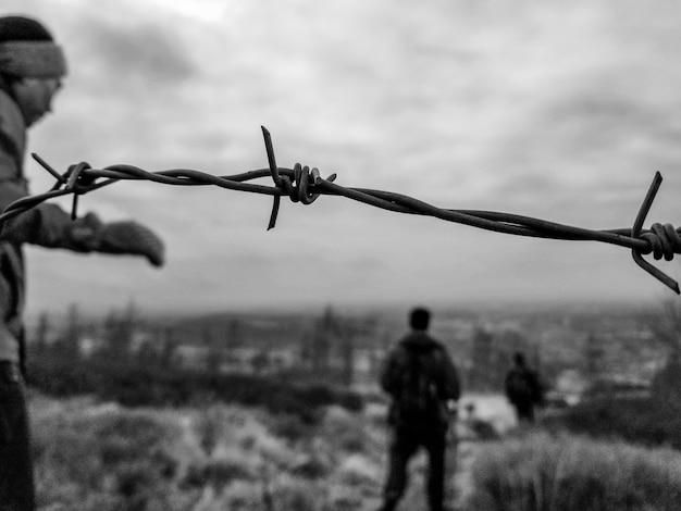 Foto primer plano de la valla de alambre de púas contra el cielo