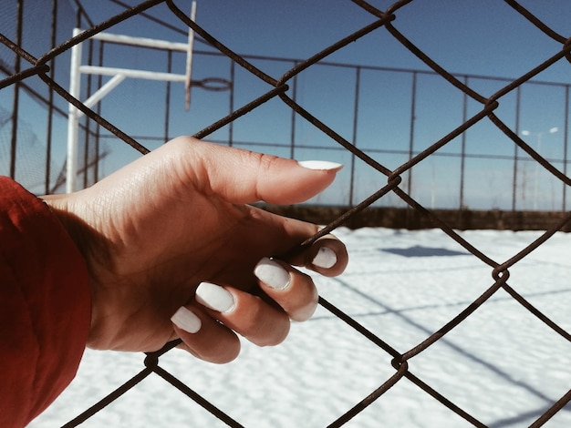 Foto primer plano de la valla de enchaines con la mano