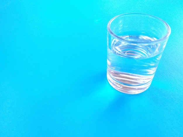 Foto primer plano de un vaso de bebida contra un fondo azul