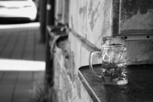 Foto primer plano de un vaso de cerveza en el alféizar de la ventana