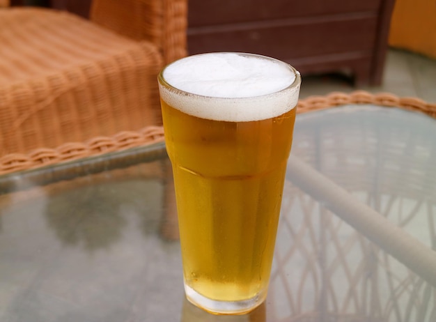 Primer plano un vaso de cerveza fría que hace agua la boca que se sirve en la mesa