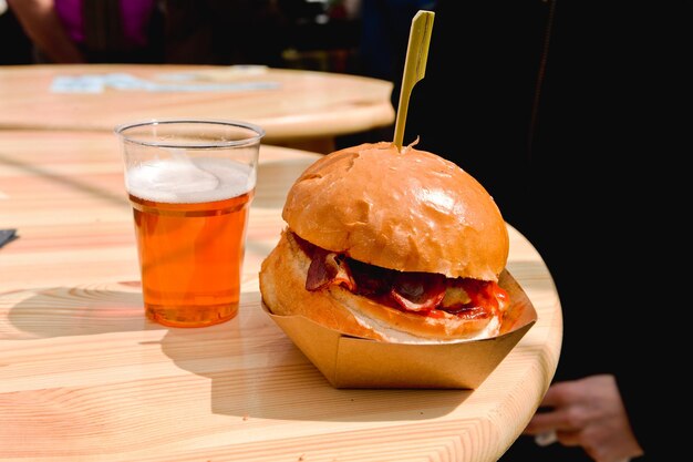 Foto primer plano de un vaso de cerveza y una hamburguesa en la mesa