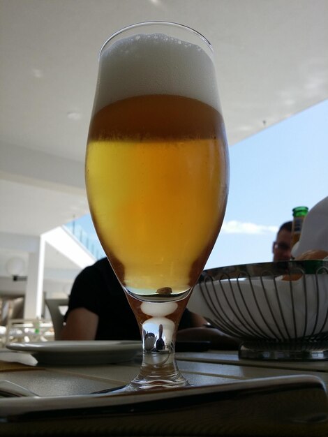 Foto primer plano de un vaso de cerveza en la mesa de un restaurante