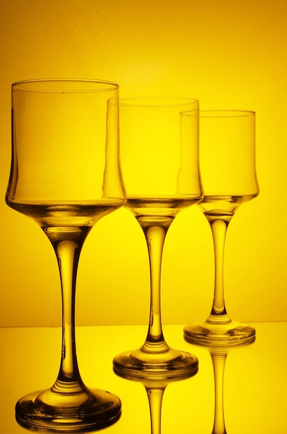 Foto primer plano de un vaso de vino en la mesa contra un fondo amarillo