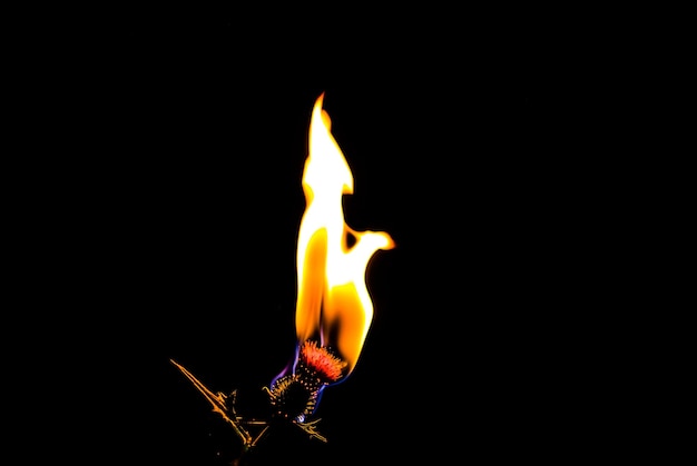 Foto primer plano de una vela ardiente contra un fondo negro