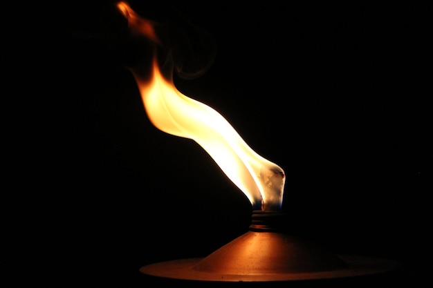Primer plano de una vela ardiente contra un fondo negro