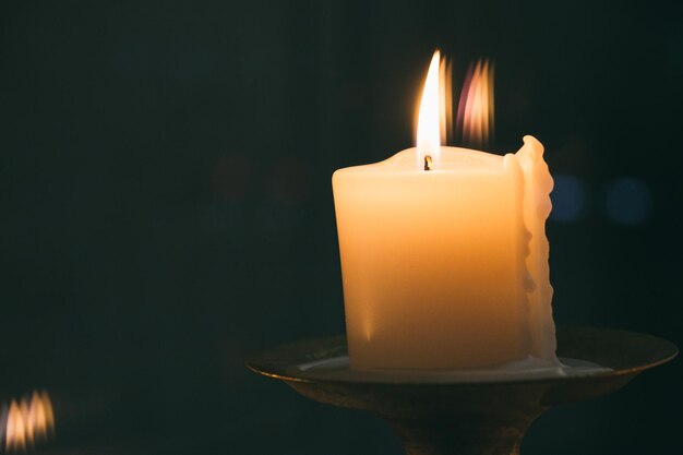 Foto primer plano de una vela ardiente en el cuarto oscuro