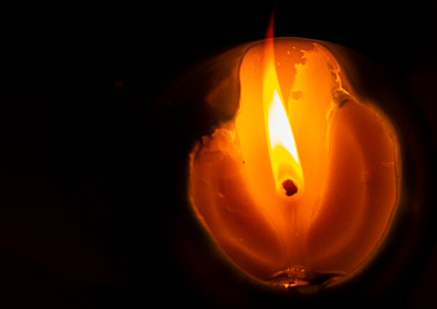 Foto primer plano de una vela encendida contra un fondo negro