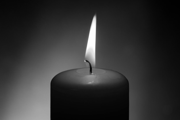 Primer plano de una vela encendida en el cuarto oscuro