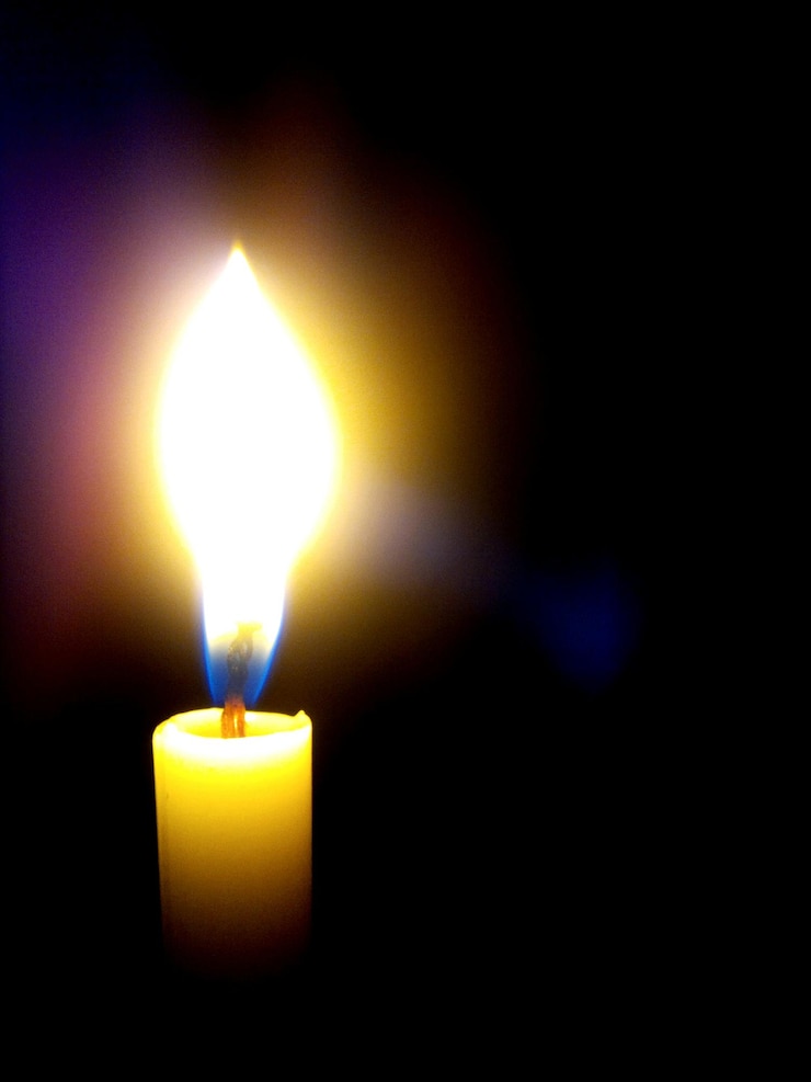 Foto primer plano de una vela encendida en el cuarto oscuro