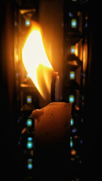 Foto primer plano de una vela iluminada en el cuarto oscuro