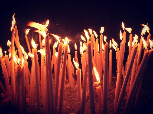 Primer plano de velas encendidas contra un fondo negro