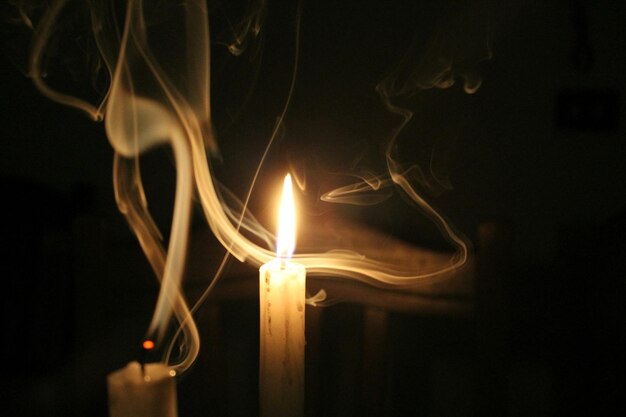 Foto primer plano de velas encendidas contra un fondo negro