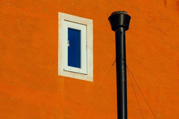 Foto primer plano de la ventana contra la pared naranja