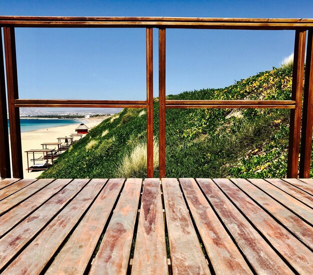 Foto primer plano de una ventana de madera con el mar en el fondo