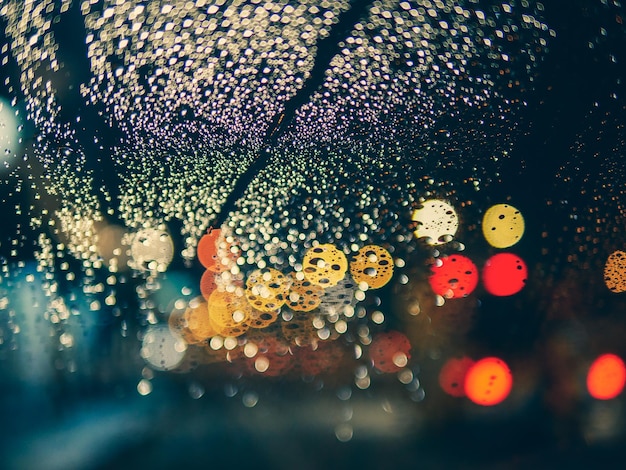 Primer plano de una ventana de vidrio húmeda durante la temporada de lluvias por la noche