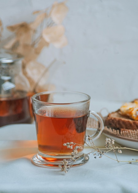 Primer plano vertical de una taza de té de hierbas caliente