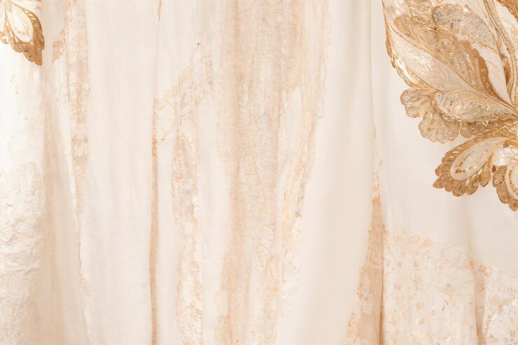 un primer plano de un vestido con una flor de oro en él