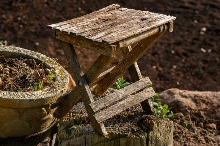 Foto primer plano de una vieja mesa de madera en miniatura en un tronco de árbol cortado y envejecido con una olla que contiene un jardín