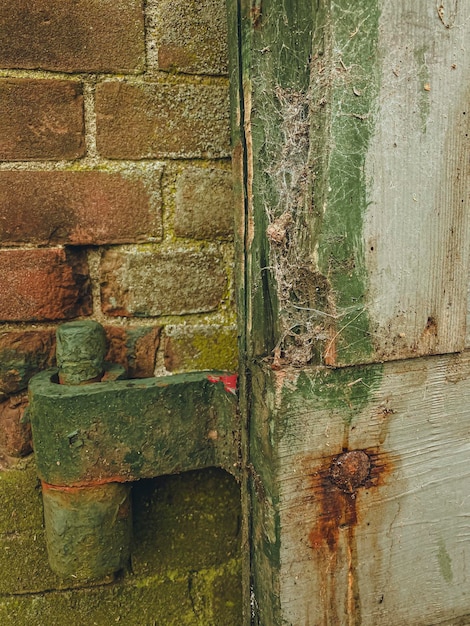 Foto un primer plano de una vieja puerta verde con bisagras de puerta oxidadas