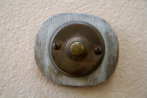 Foto primer plano de un viejo botón de campana metálico en la pared