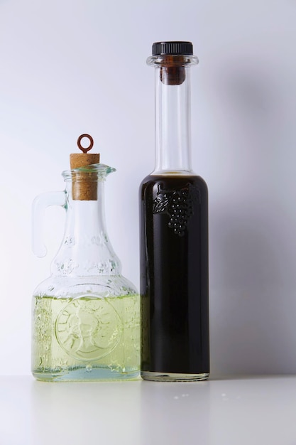 Foto primer plano de vinagre con aceite de cocina en la mesa contra un fondo blanco