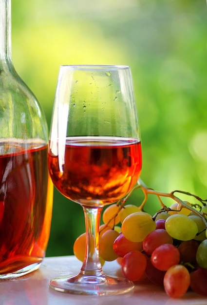 Primer plano de vino tinto y uvas en la mesa