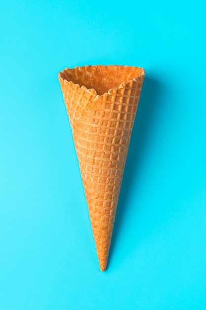 Primer plano de waffle de cono de helado vacío sobre un fondo azul claro