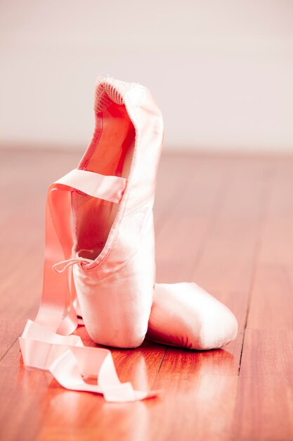 Foto primer plano de zapatos de ballet en el suelo de madera dura