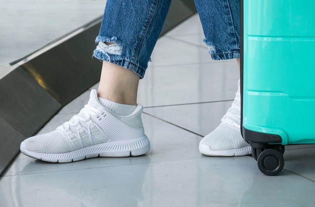 Primer plano de zapatos blancos de mujer en el aeropuerto